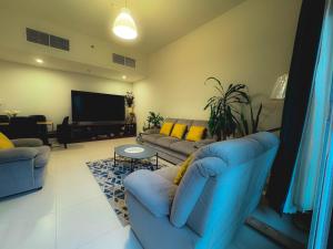 un soggiorno con divani blu e TV a schermo piatto di Modern Space in Prime Location a Dubai