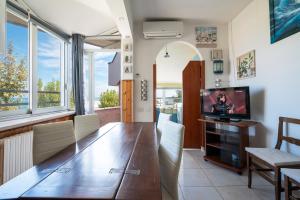 a dining room with a wooden table and a television at Desdemona in Francavilla al Mare