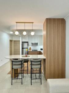 a kitchen with a island with bar stools in it at Departamento acogedor y moderno in SamborondÃ³n