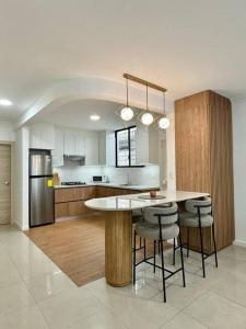 a kitchen with a table and some bar stools at Departamento acogedor y moderno in SamborondÃ³n