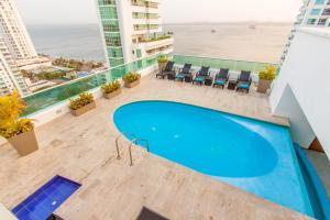 una piscina sul tetto di un edificio con vista sulla spiaggia di Travelers Orange Cartagena a Cartagena de Indias