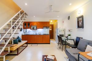 a living room and kitchen with a staircase in a room at Susegad Suites Arpora Apartments & Villas with Reserved Parking in Arpora