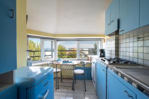 a kitchen with blue cabinets and a table with chairs at Desdemona in Francavilla al Mare