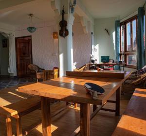 a wooden table in a room with a kitchen at Hills Tale Backpackers Hostel in Kalimpong