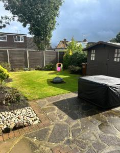 ThundersleyにあるBlue Bungalowの庭にベッドがある裏庭