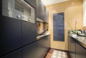 フィレンツェにあるBsj Apartmentの黒いキャビネットと壁に黒板が備わるキッチン