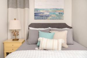 a bedroom with a bed with blue and white pillows at CDM 351 - Serendipity Sunrise in Galveston +34 photos