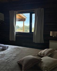 a bedroom with a large bed with a window at Piedra que late in Tandil