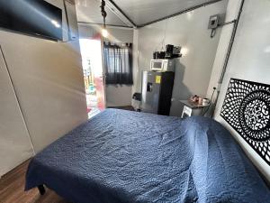 a bedroom with a blue bed and a refrigerator at Casa Faro cerca de la playa in Barra de Navidad