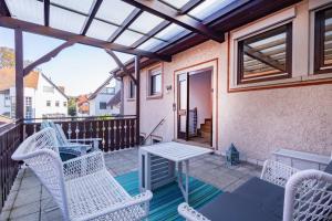 a patio with white wicker chairs and a table at Charmante Wohnung -Altes Kino- 2SZ-2Bad-Terrasse-Netflix in Baden-Baden