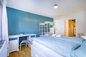 a bedroom with a large bed and a blue wall at Charmante Wohnung -Altes Kino- 2SZ-2Bad-Terrasse-Netflix in Baden-Baden
