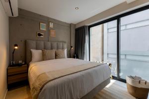 a bedroom with a large bed and a large window at Capitalia Hipodromo Condesa in Mexico City