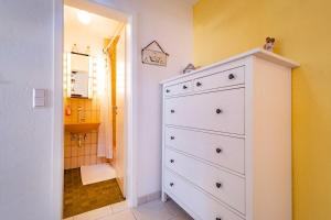 a bathroom with a white dresser and a sink at Charmante Wohnung -Altes Kino- 2SZ-2Bad-Terrasse-Netflix in Baden-Baden +25 photos