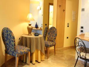 Zimmer mit einem Tisch, Stühlen und einer Lampe in der Unterkunft Blu Tropical Resort in Zambrone