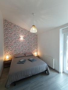 a bedroom with a large bed and a red wall at l'Estran qu'île in LʼÎle-dʼOlonne