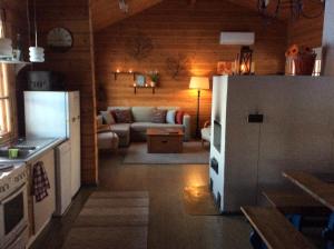 a kitchen and a living room with a white refrigerator at Annas Beach in Hausjärvi