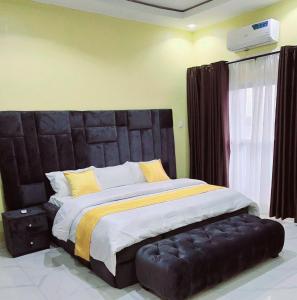 a bedroom with a large bed with a black headboard at Eden Luxurious Apartments in Mosere Ikoga