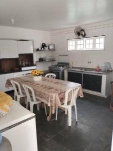 eine Küche mit einem Tisch und Stühlen in einer Küche in der Unterkunft Casa na Barra de São Miguel in Barra de São Miguel