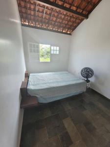 ein Schlafzimmer mit einem Bett in der Zimmerecke in der Unterkunft Casa na Barra de São Miguel in Barra de São Miguel