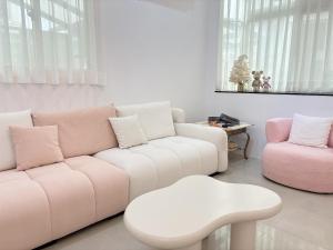 a living room with a white couch and a stool at 過家家民宿GoHouse花蓮市包棟寵物友善 in Hualien City