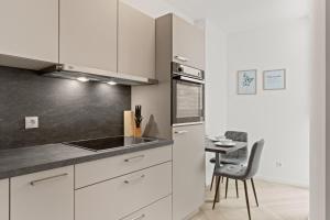 a kitchen with white cabinets and a small table at KoCASA-Apartments in Frankenthal