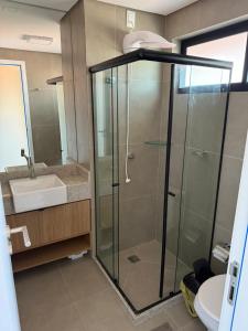 a bathroom with a glass shower and a sink at Rooftop Tamandaré - apto 106 in Tamandaré +31 photos