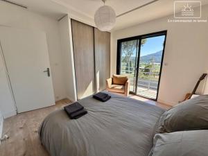 a bedroom with a large bed with a large window at La Gacélyte Piscine privée joli bas de villa in Carqueiranne +39 photos