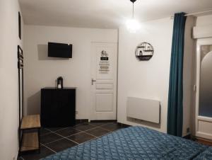 a bedroom with a bed and a television and a door at Appartement avec cour plein centre in Foix