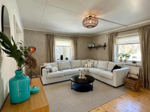 a living room with a white couch and a table at Sfeervol vakantiehuis met houtkachel in Brograngen