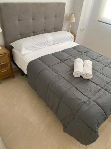 a bedroom with a bed with two towels on it at Edifico Mañez Primero- Nuevo, 10 minutos Gibraltar in La Línea de la Concepción +7 photos