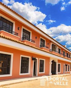 安赫莱斯镇Boutique Hotel La Casona的一座橙色的建筑,设有窗户,天空蔚蓝