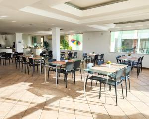 a restaurant with tables and chairs in a room at Casamar Pousada in Paulista
