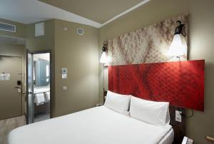a bedroom with a large bed with a red headboard at Ibis Konya in Konya +68 photos