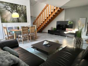 a living room with a couch and a table at Komfortables Ferienhaus in Lichtenberg bei Hof im Frankenwald 400m vom See nahe Bad Steben in Lichtenberg