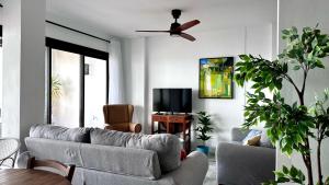 Una sala de estar con un sofá y un ventilador de techo. en Casa de la Plata Punta de la Mona, en La Herradura