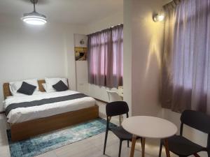 a bedroom with a bed and a table and chairs at Eydhafushi Home Stay Residence in Eydhafushi