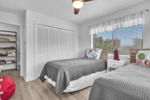 a bedroom with two beds and a window at Beach Getaway Among The Oaks in Caswell Beach +47 photos