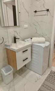 a white bathroom with a sink and a toilet at Apartment na Kowańcu in Nowy Targ