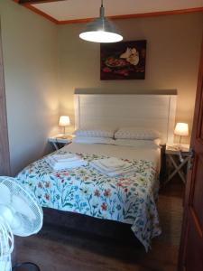 a bedroom with a bed with a floral bedspread at The Frangipani Self-catering Accommodation in George +7 photos