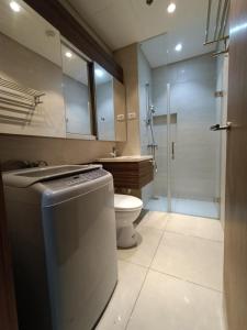 a bathroom with a toilet and a sink and a shower at Tambuli 1 Bedroom Beachfront Condo in Lapu Lapu City +28 photos