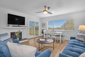 a living room with a blue couch and a table at Beach Getaway Among The Oaks in Caswell Beach