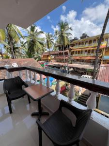 einen Balkon mit einem Tisch und Stühlen sowie Aussicht in der Unterkunft Sportsman Beach Hotel in Calangute