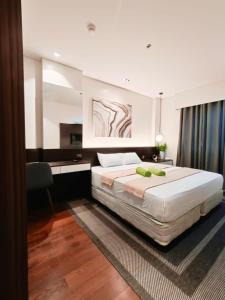 a bedroom with a large bed and a desk at Tambuli 1 Bedroom Beachfront Condo in Lapu Lapu City