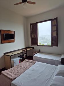 a hotel room with two beds and a window at Boa Vista in Carmo da Mata