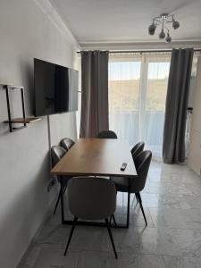 a dining room with a table and chairs and a television at Sabo Apartment in Cluj-Napoca