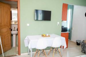 una mesa blanca con sillas blancas en la cocina en M&M Cozy Apartment 2, en Chios