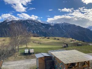 a view of a mountain range with a building at Ferienwohnung auf Ziegenhof in Alvaneu