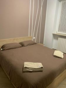 a bed with two towels on top of it at Azzurra House treno Milano in Santo Stefano Ticino