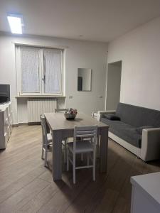 a living room with a table and a couch at Azzurra House treno Milano in Santo Stefano Ticino +3 photos