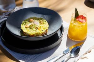 a bowl of food on a plate next to a drink at NEST Los Cabos in Santiago